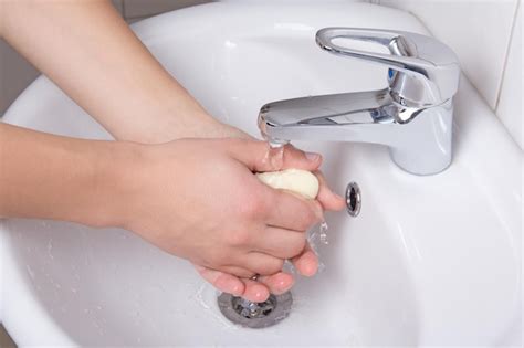 Premium Photo A Person Washing Their Hands Under A Faucet