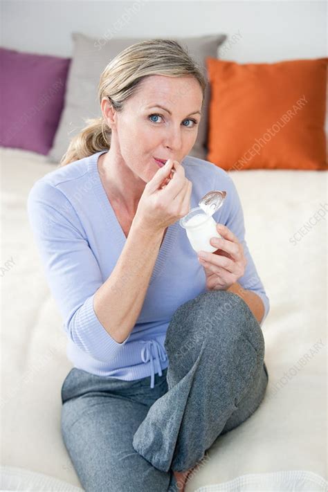 Woman Eating Yogurt Stock Image C032 6818 Science Photo Library