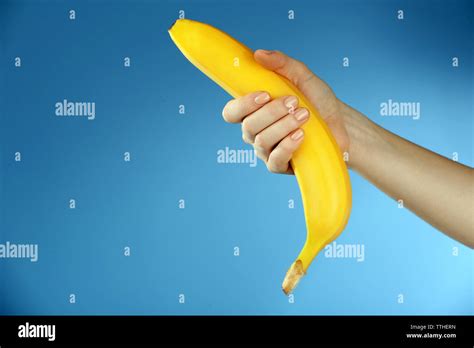 Female Hand Holding Banana On Blue Background Stock Photo Alamy