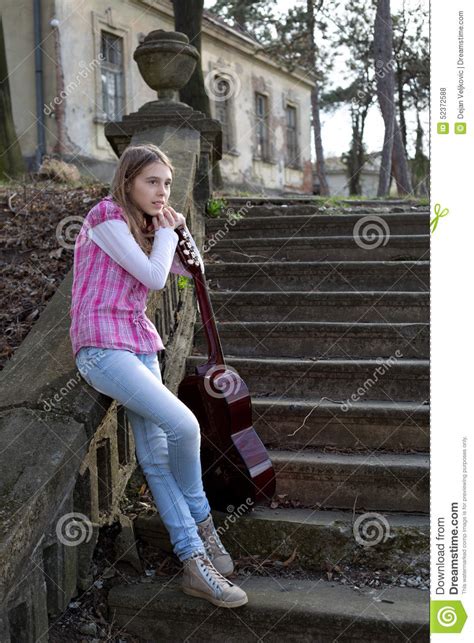 Vista Lateral Del Adolescente Con La Guitarra Que Se Inclina En La