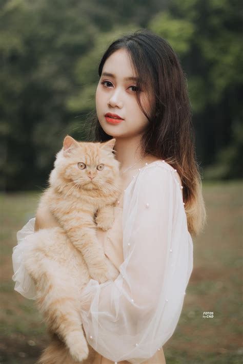 Woman Holding A Cat In Her Arms