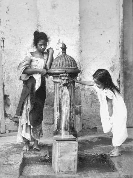 Niños recogiendo agua en una fuente publica de agua en Manila