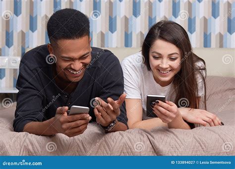 Image Of Multiracial Couple Use Modern Smart Phones And Wireless