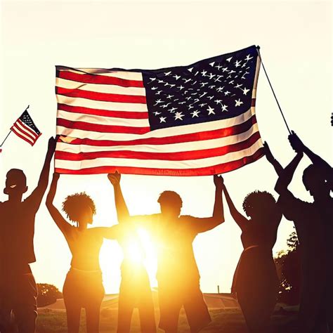 Premium Photo People Holding An American Flag In Front Of A Sunset