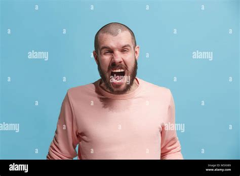 The Young Emotional Angry Man Screaming On Blue Studio Background Stock