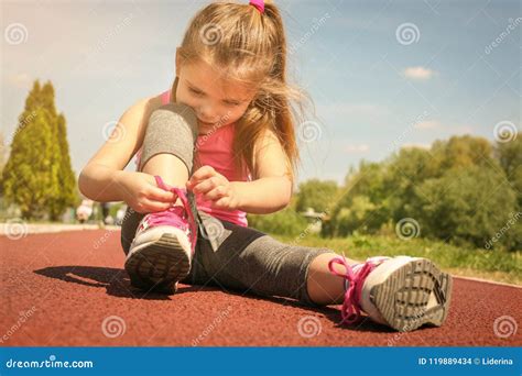 Petite Fille Attachant Des Dentelles Sur Des Espadrilles Photo Stock