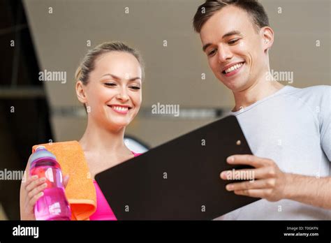 Woman And Personal Trainer With Clipboard In Gym Stock Photo Alamy