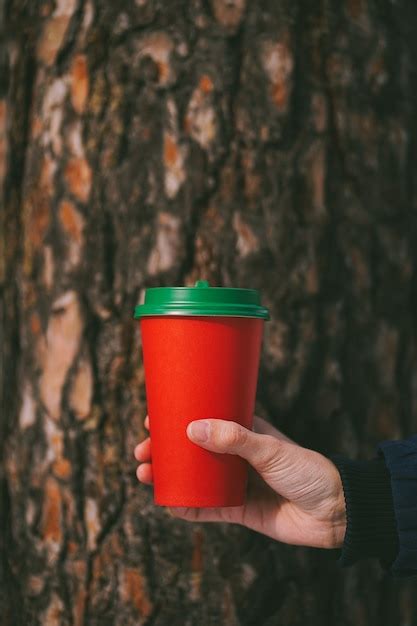 Vaso De Papel Rojo Con Tapa Verde Sobre Fondo De Rbol Foto Premium