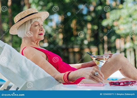 Blonde Haired Mature Woman Wearing Straw Hat Lying Near The Pool Stock Image Image Of Holiday