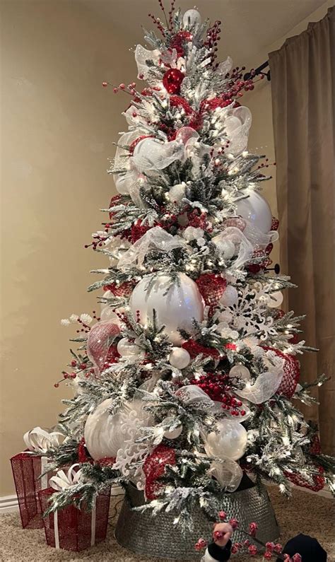 A White Christmas Tree With Red And Silver Ornaments