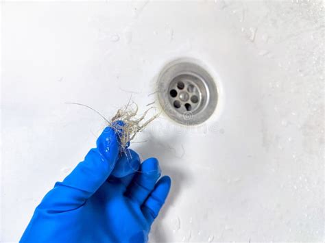 Removing Hair Clog From A Bathroom Sink Drain Gloved Hand Extracting