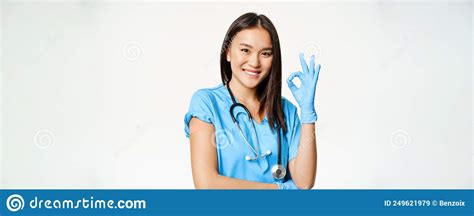 Smiling Nurse Asian Female Doctor In Scrubs Showing Okay Sign And