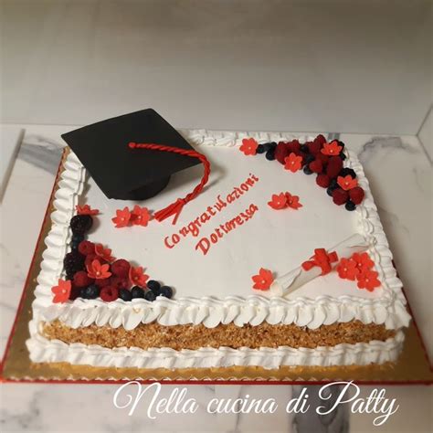 A Graduation Cake Decorated With Red And Black Flowers