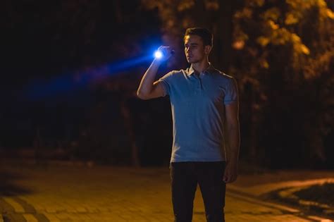 Premium Photo The Handsome Man Stand With A Flashlight On The Dark Street Night Time