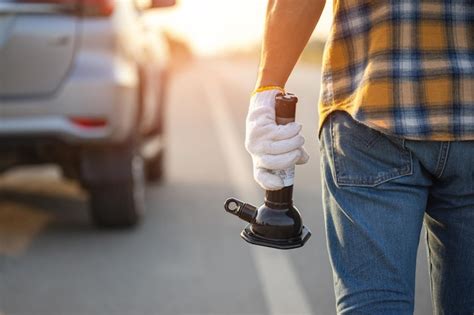 Premium Photo | Broken car on the road man holding car lifting jack to repair his car