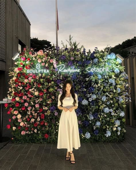 A Woman Standing In Front Of A Flower Display