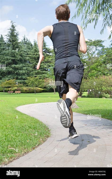 Rear View Of Man Running In Park Stock Photo Alamy