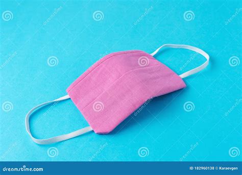 Pink Medical Face Mask On Blue Background Minimal Coronavirus Outbreak