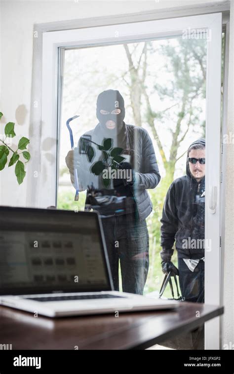 Burglar Looking At Laptop Through Window Stock Photo Alamy