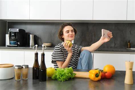 Portrait D Une Belle Femme Souriante Dans La Cuisine Prenant Un Selfie