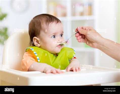 funny baby eating food on kitchen Stock Photo - Alamy