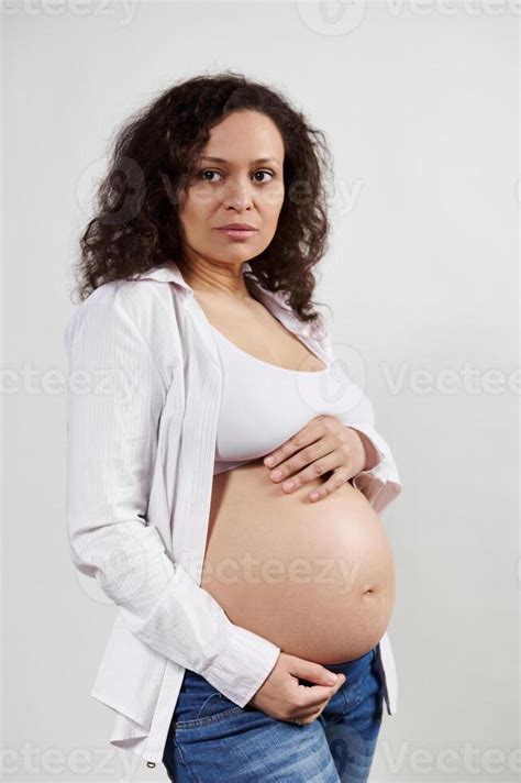 Vertical Portrait Beautiful Pregnant Hispanic Woman Expecting A Baby Posing With Hands On Naked