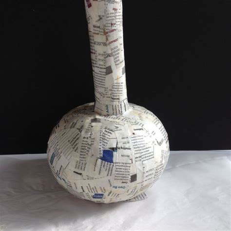 A Vase Made Out Of Newspaper Paper Sitting On Top Of A Table