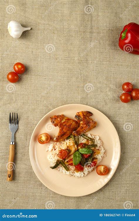 Asas De Frango Assado Em Molho De Tomate Arroz E Vegetais Em Uma