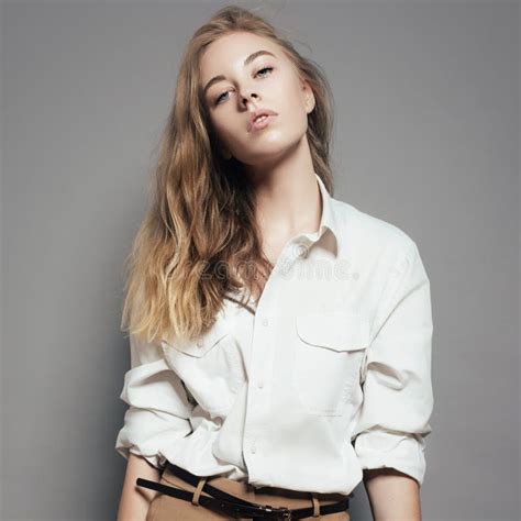 Portrait D Une Belle Jeune Femme Blonde Dans Une Chemise Blanche Dans Le Studio Sur Un Fond Gris