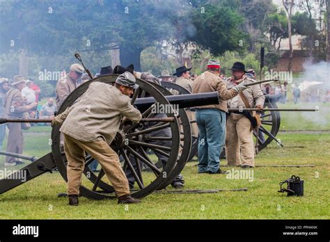 Confederate Soldiers Firing A Cannon During A Battle At A American