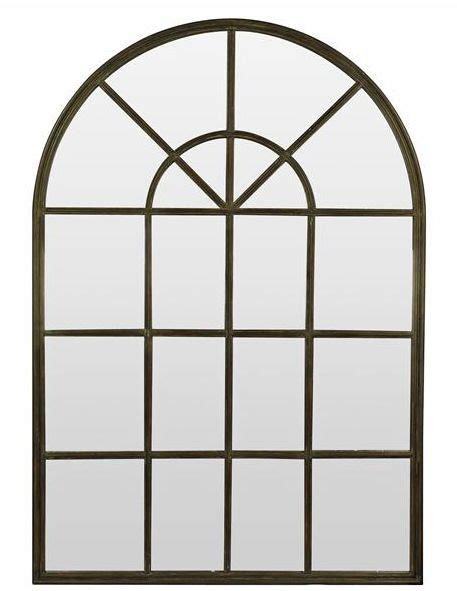 An Arched Window With Glass And Metal Bars On The Bottom Against A