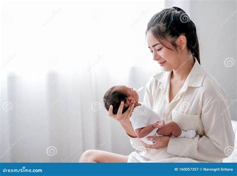 Asian Mother Hold Or Carry Her Newborn Baby And Look To Baby Face With