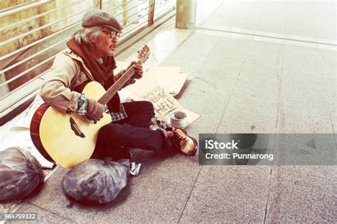 Beautiful Homeless Man Playing Guitar On Walking Street In The Capital