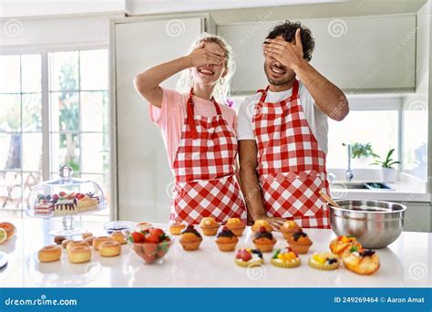 Couple Of Wife And Husband Cooking Pastries At The Kitchen Smiling And Laughing With Hand On