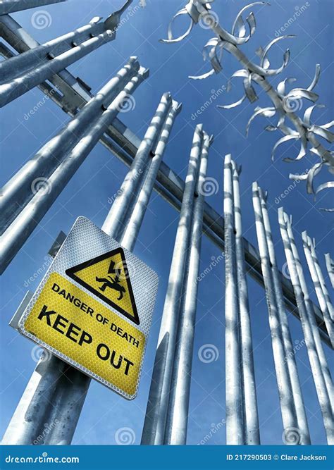 A Metal Fence Keeping Trespassers Out With A Warning Sign Stating