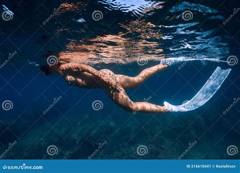 Naked Sporty Woman With Freediving Fins Swim In Transparent Ocean Stock