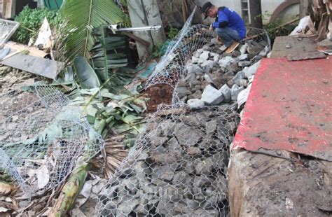 Petugas Dinas Perairan Membuat Tanggul Atasi Banjir Foto