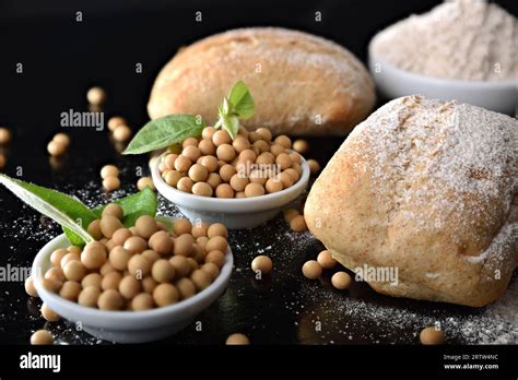 Bread rolls with soy flour on black kitchen bench with bowls full of ...