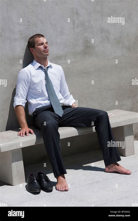 Barefoot Businessman Sitting On Bench Enjoying The Sun Stock Photo Alamy