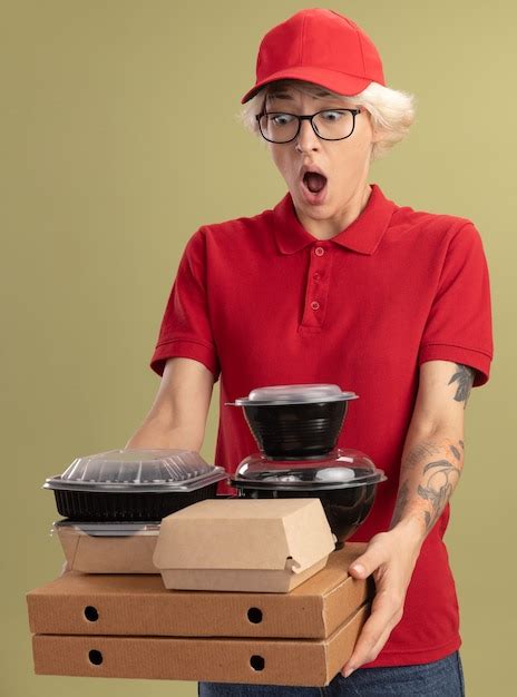 Repartidor Joven En Uniforme Rojo Y Gorra Con Gafas Sosteniendo Cajas