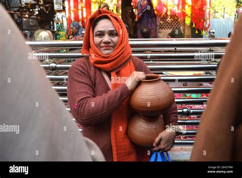 Mujeres devotas paquistaníes que traen agua para la ablución de las