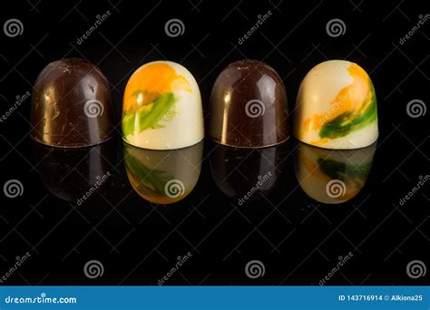 Closeup Four Sphere Shaped Candies Form White And Black Chocolate Stock