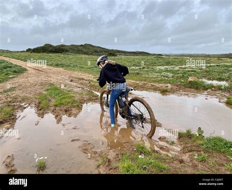 Girl Stuck In The Mud While Riding A Mountain Bike Along A Dirt Trail