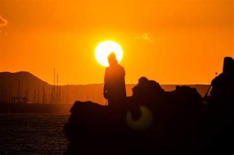 Premium Photo | Fisherman fishing rod silhouette at orange sunset