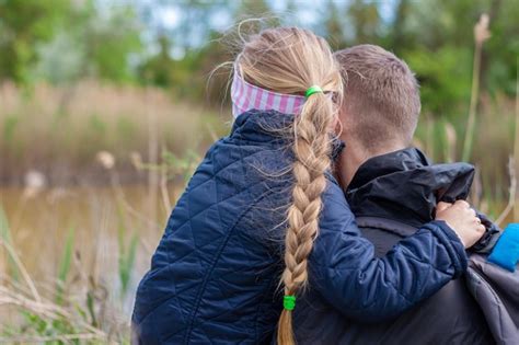 Padre e hija sentados junto al lago en el paisaje natural niña con