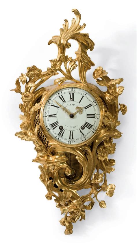 An Ornate Gold Clock With Roman Numerals And Flowers On The Face Is Shown