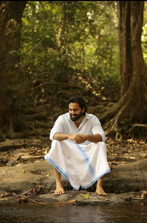 A Man Sitting On The Ground In Front Of A River Holding A White Cloth