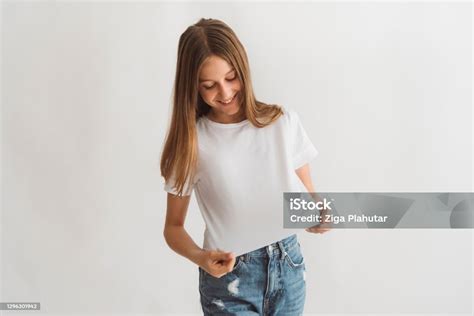 Young Teenage Girl Looking Down On Her Basic White Tshirt Stock Photo