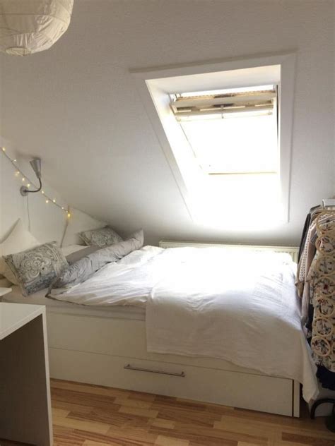 A Bed Sitting Under A Window In A Bedroom Next To A White Desk And Chair