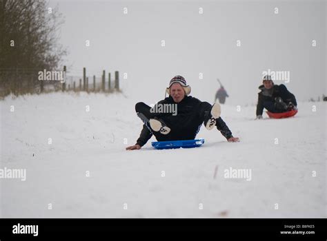 Teenagers having fun sledging in the snow on an improvised sledge Stock ...